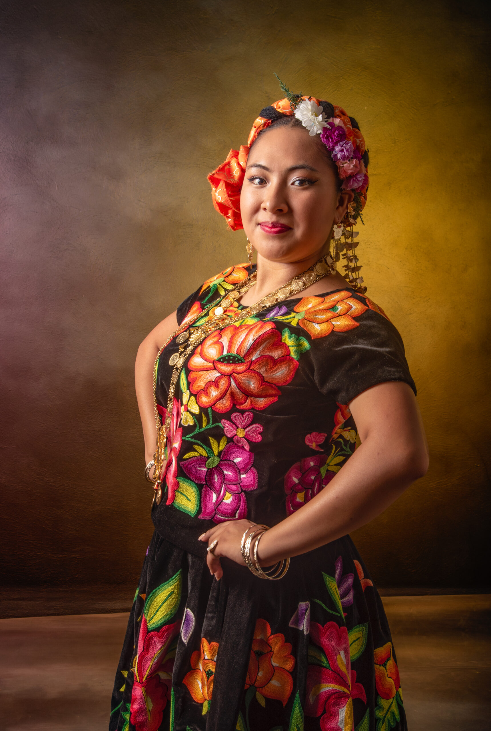 Oaxaca mexican latin woman wearing a dress from istmo guelaguetza mexico A woman in a colorful dress with flowers on it poses for a photo. The dress is adorned with a variety of flowers and the woman is wearing a flower headband. Scene is cheerful and vibrant